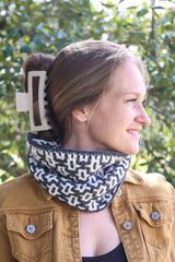 Woman in grey & white cowl outside, looking to the side thumbnail
