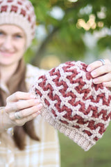 Woman holding hat toward viewer thumbnail