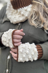 Close up of cream & brown crochet mitts. thumbnail