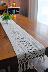 Full view of crochet table runner, with fringe draped over end of table. thumbnail
