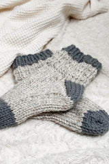 Chunky socks laying on cream blanket. thumbnail