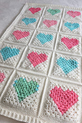 Close up of crochet blanket showing border on individual blocks and around entire blanket. thumbnail