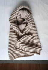 Top down view of beige knit scarf, curled and laid on white background. thumbnail