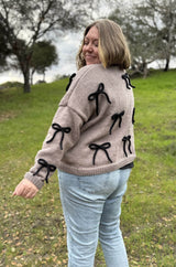 Side view of cardigan showing shoulder seam and two bows on sleeves. thumbnail