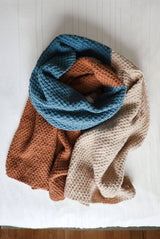 Blanket scarf wrapped into a circle, laid on cream background. thumbnail