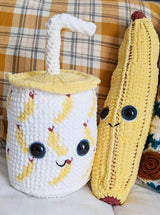 Close up of banana smoothie cup and a stuffed banana. thumbnail