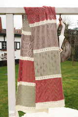 Lace wrap draped over garden trellis, showing different lace patterns and colors in each section. thumbnail