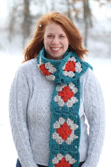 Front view of woman in grey sweater standing outside. She wears a crochet scarf draped around and over one shoulder. thumbnail