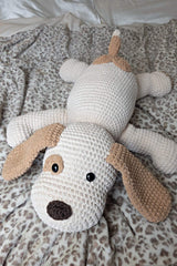 Stuffed dog laying on leopard printed fuzzy blanket. The dog has a dark brown nose, black plastic eyes, a white body, and tan ears. It has a patch around one eye and a heart-shaped patch around the tail., which is also tan and tipped with white. thumbnail