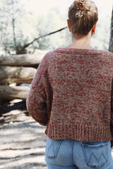 Back view of marled knit cardigan, worn with blue jeans and photographed outside. The cardigan body is cropped, with a wide ribbed hem and a ribbed neckband. thumbnail