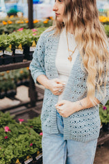 Front view of crochet cardigan with ribbed front bands. The woman wears it over a white tee shirt and jeans. thumbnail
