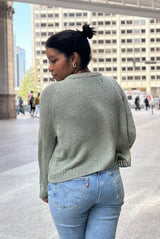 Back view of knit sweater in pale green, showing raglan lines and ribbed collar and hem. thumbnail