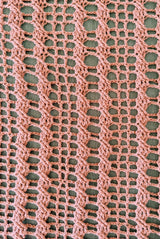 Close up view of open grid pattern on blanket with vertical cables. blanket is stretched open. thumbnail