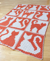 Low angle full view of crochet blanket, showing 3 wide by 4 high bock layout. thumbnail