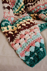 Close up of blanket corner, showing one row stripes in various colors and textures. thumbnail