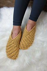 pair of mustard yellow crocheted Willow slippers worn on feet over a fluffy white rug thumbnail