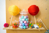Jumbo lollipop crafts surrounded by candy in jars and kids toys thumbnail