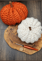 crocheted orange pumpkin next to a white one thumbnail