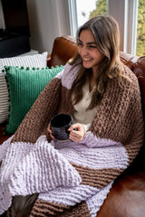 girl wrapped in knit blanket holding a mug thumbnail
