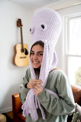 Girl with oversized octopus stuffed animal on her head thumbnail