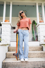 woman wearing knit tee holding skateboard thumbnail