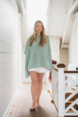 woman wearing hooded poncho thumbnail