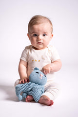 baby holding blue knit kitty lovey in front of white background thumbnail