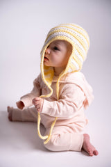 baby wearing white and yellow baby hat with ear flaps thumbnail