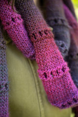 close-up of a pink and purple eyelet-stitch knit scarf worn over a green jacket thumbnail