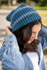 close-up of a person wearing a blue knit hat denim jacket and white shirt outdoors thumbnail