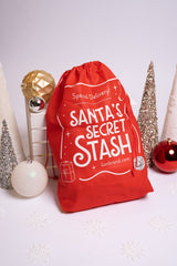 Santa's Secret Stash drawstring bag surrounded by Christmas decorations thumbnail