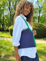 Woman with a crochet tote bag with special shaping, in green and blue on her shoulder. thumbnail