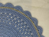 close-up of dusty blue crocheted placemat showing gold surface stitch detail, scalloped edge, and openwork lattice stitches thumbnail