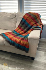 colorful crocheted throw blanket in colorful self-striping yarn draped over a couch thumbnail