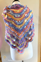 pastel virus stitch crochet shawl displayed on a mannequin with multicolor yarn thumbnail