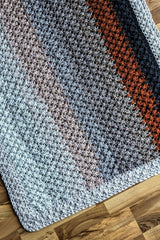 flat-lay of striped crochet blanket thumbnail