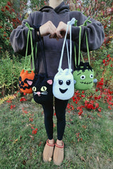 person holding four Halloween crochet treat bags in the shape of a black cat ghost frankenstein monster and jack-o-lantern thumbnail