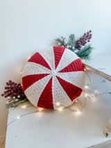 handmade peppermint wheel crochet pillow surrounded by branches and lights thumbnail
