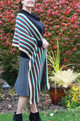 woman wearing a long teal, white, and red striped crocheted super scarf wrap outdoors thumbnail
