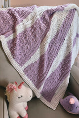 Purple and white baby blanket draped on a chair thumbnail