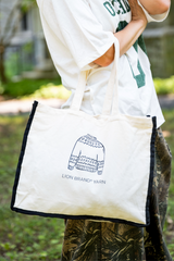 woman holding fair isle canvas tote with black piping around border  thumbnail