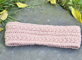 textured star stitch crochet headband laid flat on a grey stone surface thumbnail