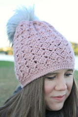 woman wearing a dusty pink crocheted beanie with a fur pom-pom thumbnail