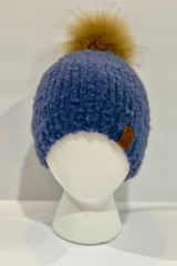 blue knit beanie on a white foam mannequin head, topped with a fluffy faux-fur pom-pom and finished with a branded side tag thumbnail