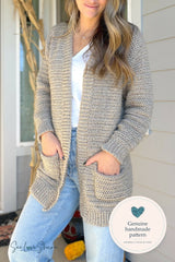 person wearing a beige crochet cardigan jeans and white shirt standing near a blue door thumbnail