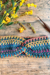 Crochet headband with yellow flowers and a crochet hook thumbnail