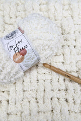 Sherpa yarn skein, crochet hook on top of blanket thumbnail