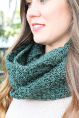 forest green crocheted infinity cowl scarf in sedge stitch worn around the neck of a blonde woman thumbnail