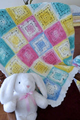 crochet granny square blanket with a stuffed bunny thumbnail