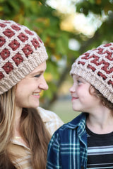 Woman and child look at each other while wearing hats thumbnail